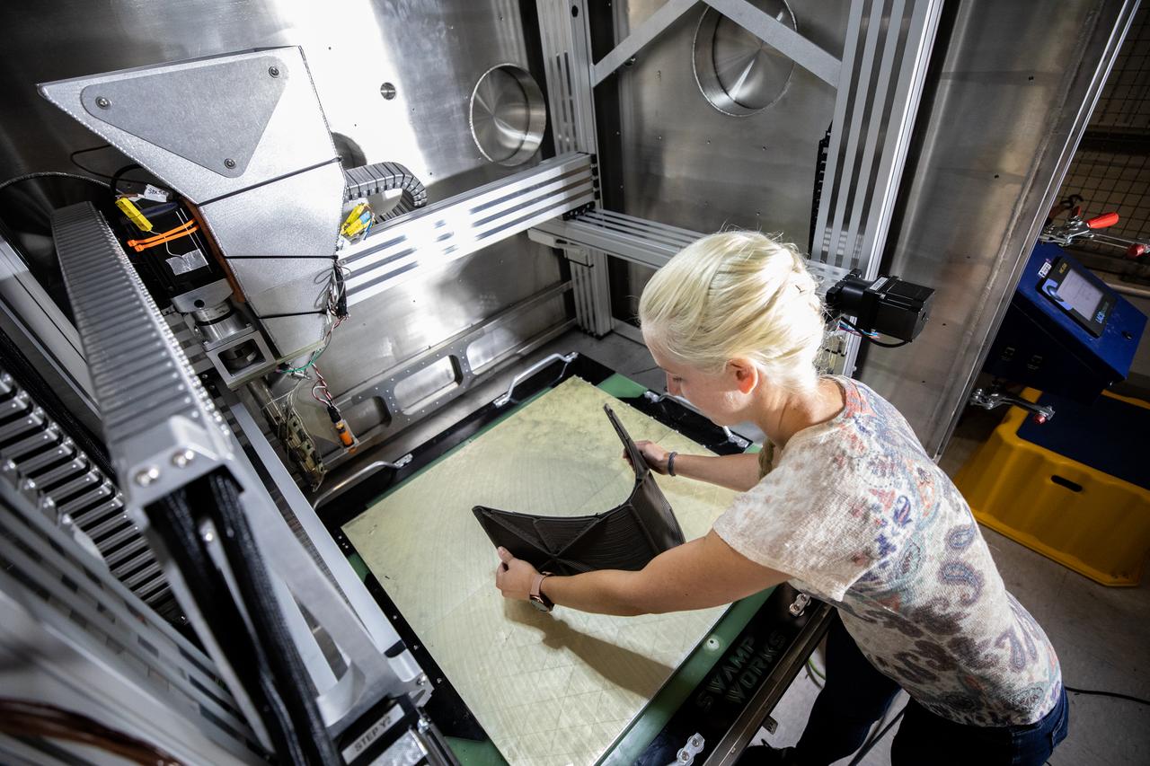 Chemist Tesia Irwin tests a 3D printer on July 28, 2022, at Swamp Works at NASA’s Kennedy Space Center in Florida, as part of the Relevant Environment Additive Construction Technology (REACT) project. Among the key objectives of the project is developing an architectural and structural design for a shelter that provides protection to habitable assets on the lunar surface. Testing REACT derives from NASA’s 2020 Announcement of Collaboration Opportunity with AI SpaceFactory – an architectural and construction technology company and winner of NASA’s 3D Printed Habitat Challenge.
