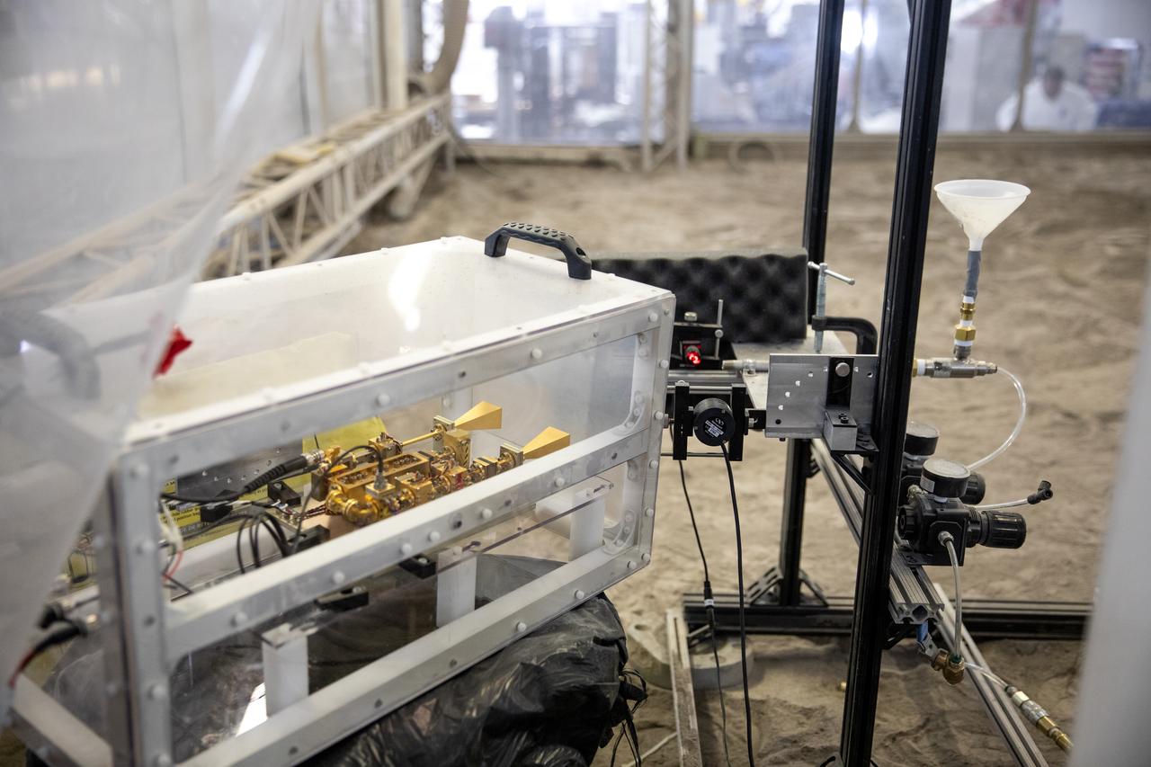 A team at NASA’s Kennedy Space Center in Florida assesses the Dust Concentration Monitor and the Millimeter Wave Doppler Radar inside a regolith bin at the Granular Mechanics and Regolith Operations (GMRO) lab at the spaceport’s Swamp Works on July 28, 2022, as part of Plume Surface Interaction (PSI) Instrumentation testing. The PSI Project is advancing both modeling and testing capabilities to understand exactly how rocket exhaust plumes affect a planetary landing site. This advanced modeling will help engineers evaluate the risks of various plumes on planetary surfaces, which will help them more accurately design landers for particular locations. 