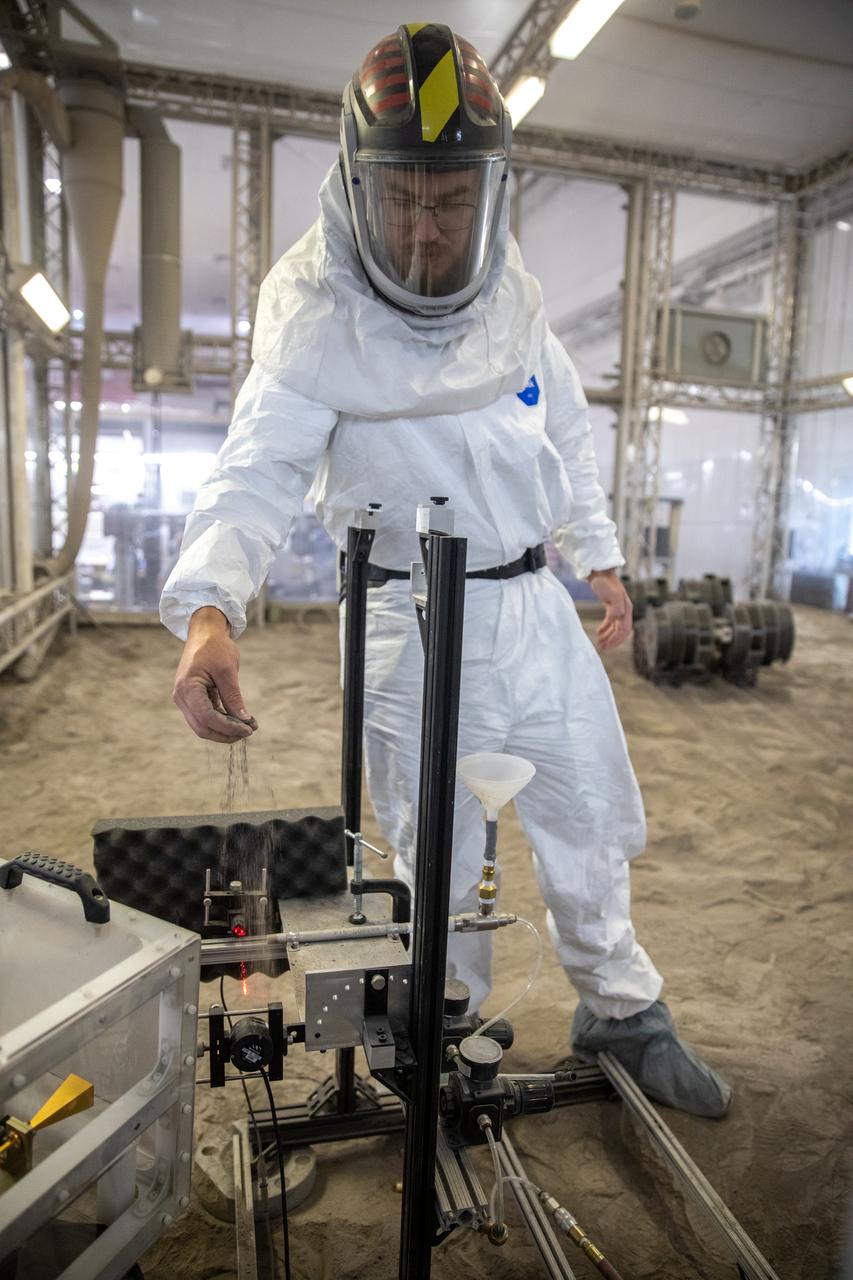 A team at NASA’s Kennedy Space Center in Florida assesses the Dust Concentration Monitor and the Millimeter Wave Doppler Radar inside a regolith bin at the Granular Mechanics and Regolith Operations (GMRO) lab at the spaceport’s Swamp Works on July 28, 2022, as part of Plume Surface Interaction (PSI) Instrumentation testing. The PSI Project is advancing both modeling and testing capabilities to understand exactly how rocket exhaust plumes affect a planetary landing site. This advanced modeling will help engineers evaluate the risks of various plumes on planetary surfaces, which will help them more accurately design landers for particular locations. 
