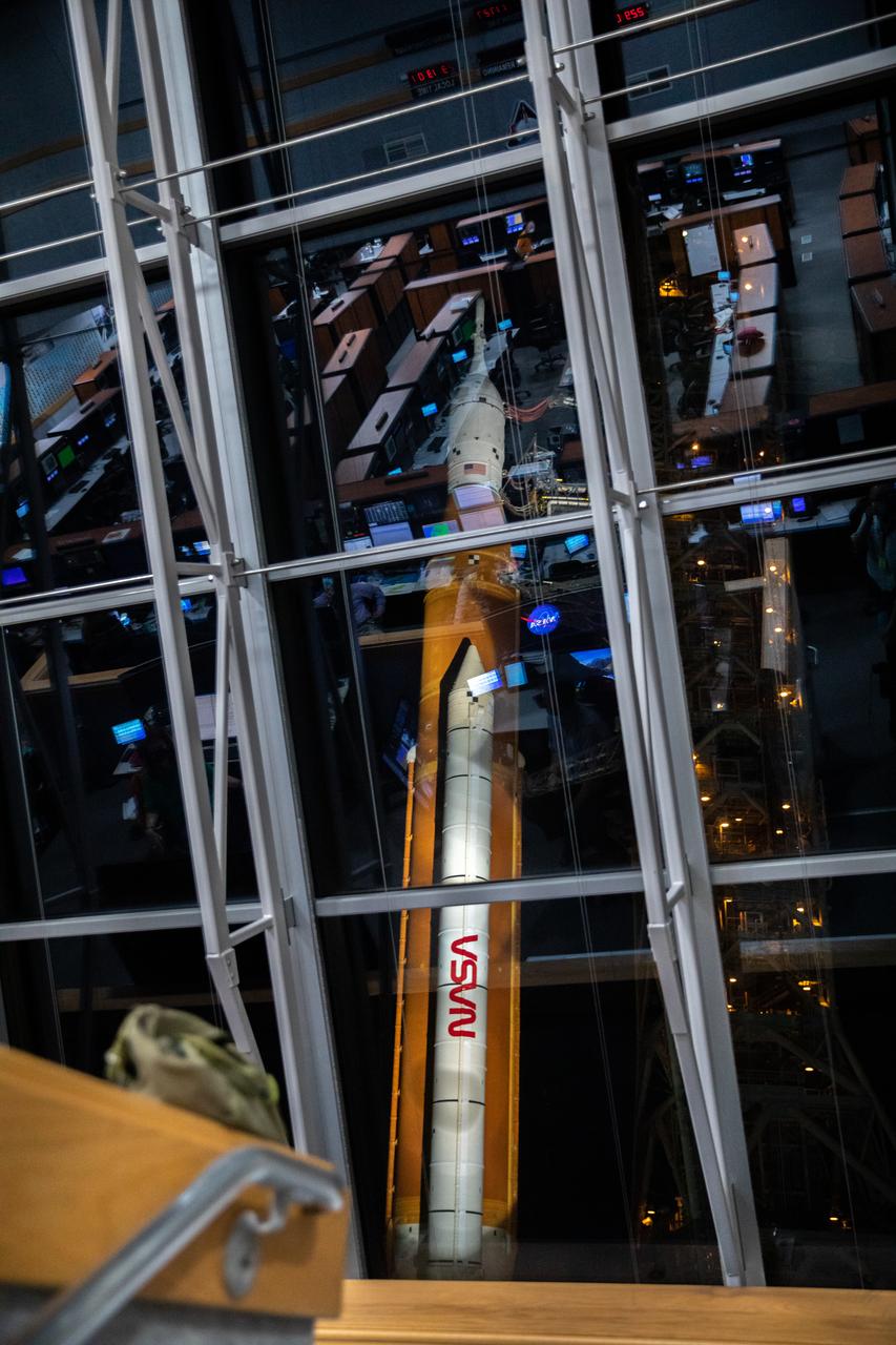 NASA’s Space Launch System (SLS) rocket with the Orion spacecraft atop a mobile launcher is seen through the windows of Firing Room 1 in the Rocco A. Petrone Launch Control Center as it rolls out of High Bay 3 of the Vehicle Assembly Building to Launch Complex 39B, on Tuesday, Aug. 16, 2022, ahead of the agency’s Artemis I flight test. The fully stacked and integrated SLS rocket and Orion spacecraft is scheduled to liftoff on Monday, Aug. 29. The first in a series of increasingly complex missions, Artemis I will provide a foundation for human deep space exploration and demonstrate our commitment and capability to extend human presence to the Moon and beyond. The primary goal of Artemis I is to thoroughly test the integrated systems before crewed missions by launching Orion atop the SLS rocket, operating the spacecraft in a deep space environment, testing Orion’s heat shield, and recovering the crew module after reentry, descent, and splashdown. In later missions, NASA will land the first woman and the first person of color on the surface of the Moon, paving the way for a long-term lunar presence and serving as a steppingstone on the way to Mars.