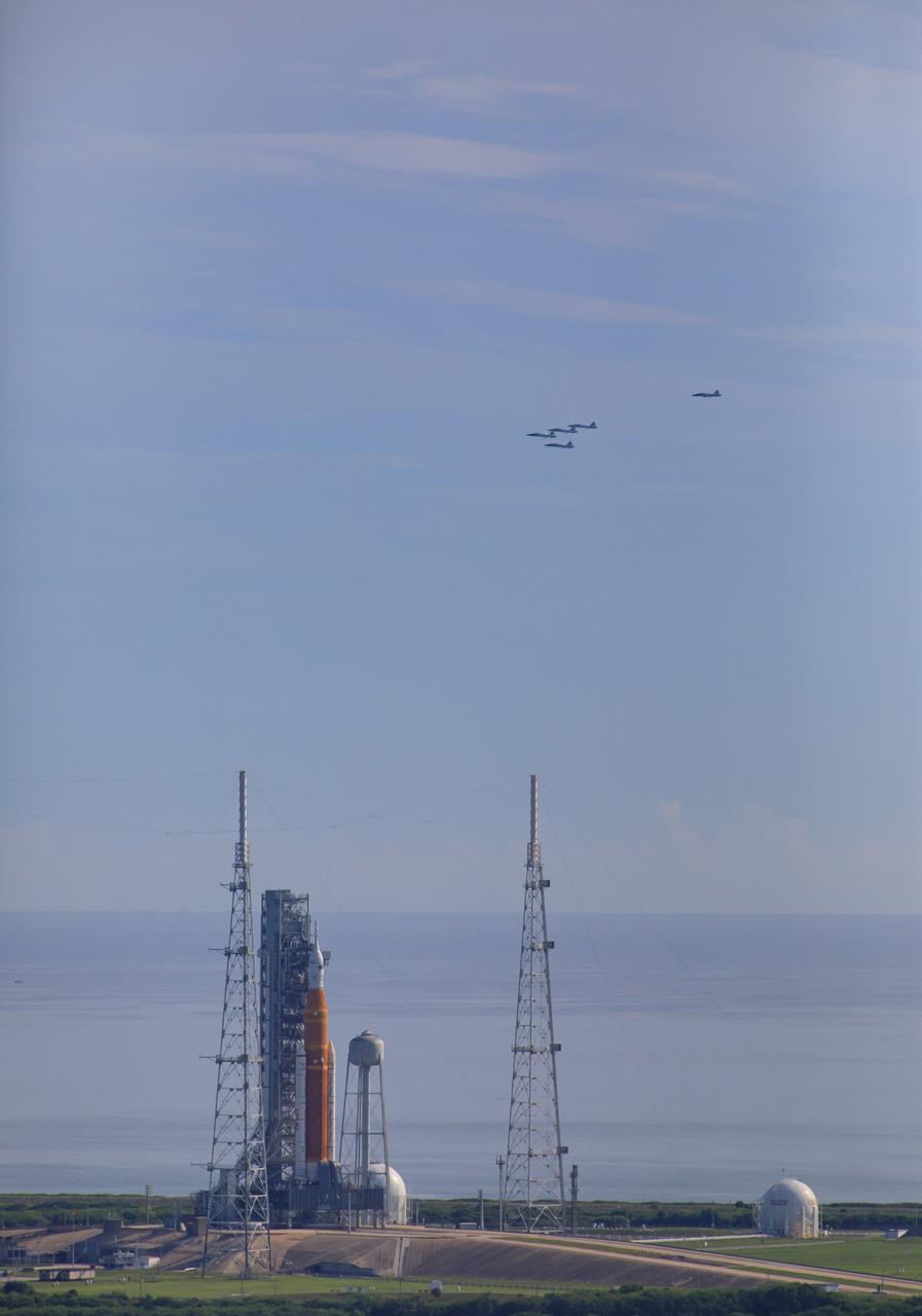 Ahead of NASA’s Artemis I launch, a flight of T-38 supersonic trainer aircraft from the Johnson Space Center Aircraft Operations Division flies in formation over the agency’s Space Launch System and Orion spacecraft on the pad at Launch Complex 39B at Kennedy Space Center in Florida, on Aug. 23, 2022. Pilots and passengers of the five aircraft include NASA Research Pilot Chris Condon and NASA Astronaut Zena Cardman in the lead plane, followed by NASA astronaut candidate Nicole Ayers and NASA astronaut Christina Koch in the second plane, Canadian Space Agency astronaut Jeremy Hansen and NASA astronaut Drew Morgan in the third plane, NASA astronaut Reid Wiseman and NASA astronaut Joe Acaba in the fourth plane, and NASA astronaut candidate Jack Hathaway and Josh Valcarcel, NASA photographer, in the chase plane. Artemis I is scheduled to launch at 8:33 a.m. EDT on Aug. 29, 2022. The first in a series of increasingly complex missions, Artemis I will provide a foundation for human deep space exploration and demonstrate our commitment and capability to extend human presence to the Moon and beyond. The primary goal of Artemis I is to thoroughly test the integrated systems before crewed missions by operating the spacecraft in a deep space environment, testing Orion’s heat shield, and recovering the crew module after reentry, descent, and splashdown.