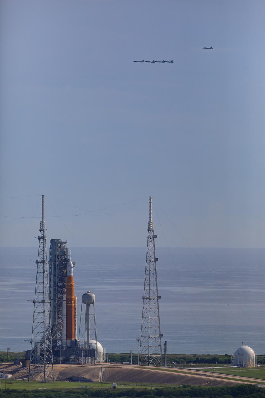 Ahead of NASA’s Artemis I launch, a flight of T-38 supersonic trainer aircraft from the Johnson Space Center Aircraft Operations Division flies in formation over the agency’s Space Launch System and Orion spacecraft on the pad at Launch Complex 39B at Kennedy Space Center in Florida, on Aug. 23, 2022. Pilots and passengers of the five aircraft include NASA Research Pilot Chris Condon and NASA Astronaut Zena Cardman in the lead plane, followed by NASA astronaut candidate Nicole Ayers and NASA astronaut Christina Koch in the second plane, Canadian Space Agency astronaut Jeremy Hansen and NASA astronaut Drew Morgan in the third plane, NASA astronaut Reid Wiseman and NASA astronaut Joe Acaba in the fourth plane, and NASA astronaut candidate Jack Hathaway and Josh Valcarcel, NASA photographer, in the chase plane. Artemis I is scheduled to launch at 8:33 a.m. EDT on Aug. 29, 2022. The first in a series of increasingly complex missions, Artemis I will provide a foundation for human deep space exploration and demonstrate our commitment and capability to extend human presence to the Moon and beyond. The primary goal of Artemis I is to thoroughly test the integrated systems before crewed missions by operating the spacecraft in a deep space environment, testing Orion’s heat shield, and recovering the crew module after reentry, descent, and splashdown.