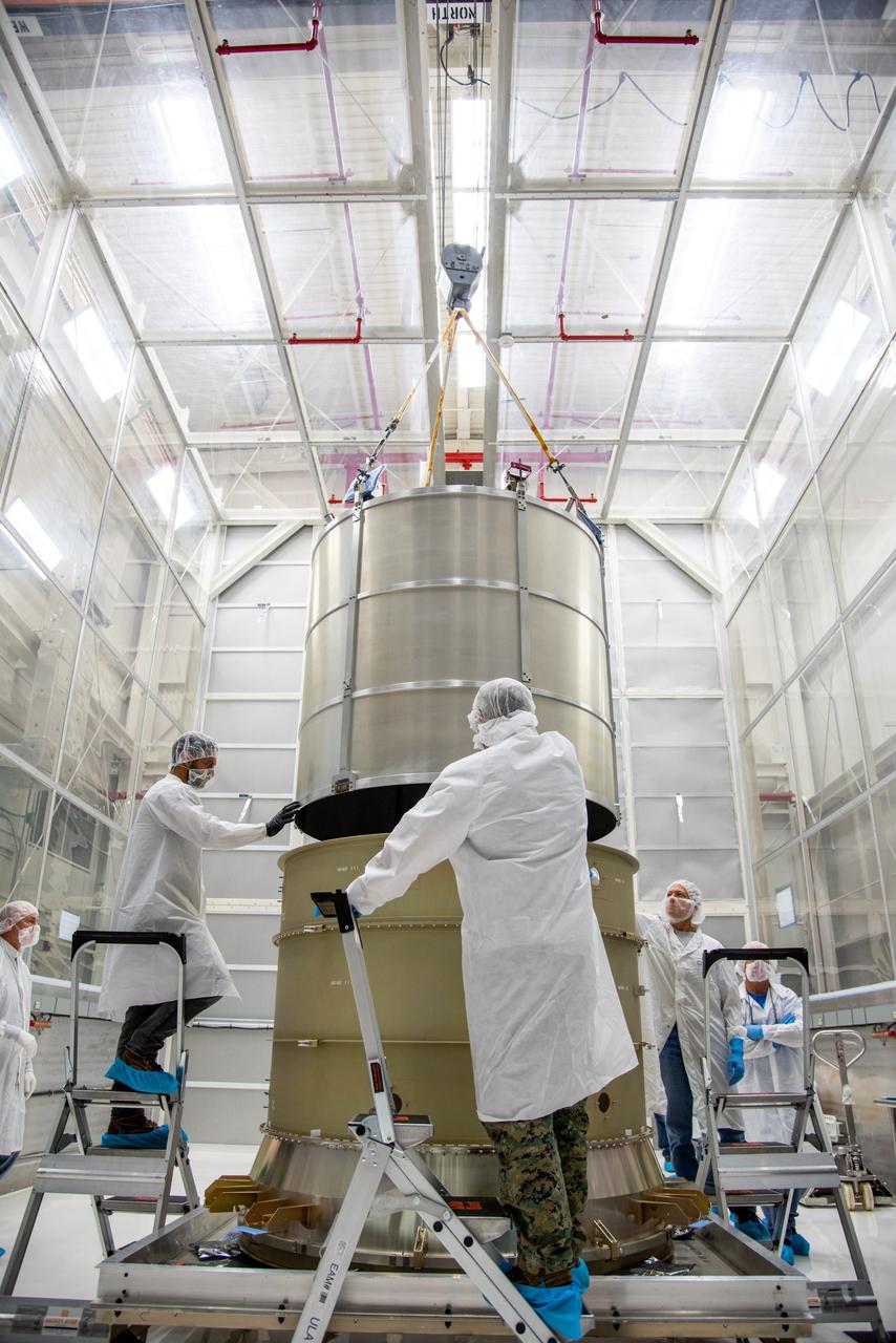 Technicians lower the payload adapter separation systems canister for the Low-Earth Orbit Flight Test of an Inflatable Decelerator (LOFTID) into the payload adapter canister as part of launch preparations inside Building 836 at Vandenberg Space Force Base (VSFB) in California on Sept. 1, 2022. LOFTID is the secondary payload on NASA and the National Oceanic and Atmospheric Administration’s (NOAA) Joint Polar Satellite System-2 (JPSS-2) satellite mission. JPSS-2 is the third satellite in the Joint Polar Satellite System series. It is scheduled to lift off from VSFB on Nov. 1 from Space Launch Complex-3. JPSS-2, which will be renamed NOAA-21 after reaching orbit, will join a constellation of JPSS satellites that orbit from the North to the South pole, circling Earth 14 times a day and providing a full view of the entire globe twice daily. LOFTID will demonstrate inflatable heat shield technology that could enable a variety of proposed NASA missions to destinations such as Mars, Venus, and Titan, as well as returning heavier payloads from low-Earth orbit. 