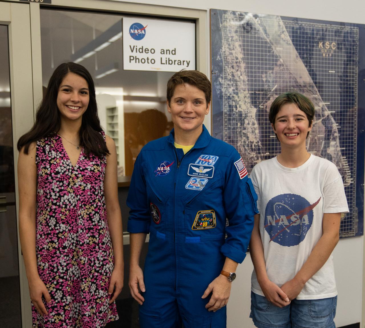 Student essay winners Amanda Gutierrez, left, and Taia Saurer pose with NASA astronaut Anne McClain at the agency’s news center at Kennedy Space Center in Florida on Sept. 2, 2022. Gutierrez and Saurer won the Artemis Moon Pod Essay Contest – a nationwide event involving nearly 14,000 students – for their creative visions of a pioneering journey to the Moon. The grand prize was a trip to Kennedy to watch the launch of Artemis I. Gutierrez, 17, is an 11th-grader from Lincoln, Nebraska, while Saurer, 14, is an eighth-grader from Laguna Beach, California.