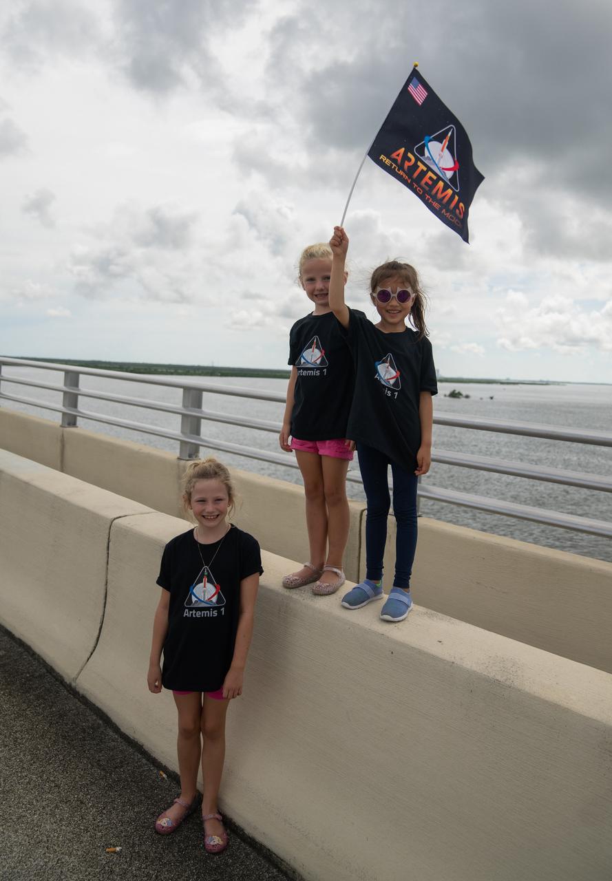 A group of young children with an Artemis flag are photographed on the Max Brewer Bridge in Titusville, Florida, as they wait to watch the launch of NASA’s Artemis I mission on Sept. 3, 2022. The launch was waived off for the day. The first in a series of increasingly complex missions, Artemis I will provide a foundation for human deep space exploration and demonstrate our commitment and capability to extend human presence to the Moon and beyond. The primary goal of Artemis I is to thoroughly test the integrated systems before crewed missions by operating the spacecraft in a deep space environment, testing Orion’s heat shield, and recovering the crew module after reentry, descent, and splashdown. 