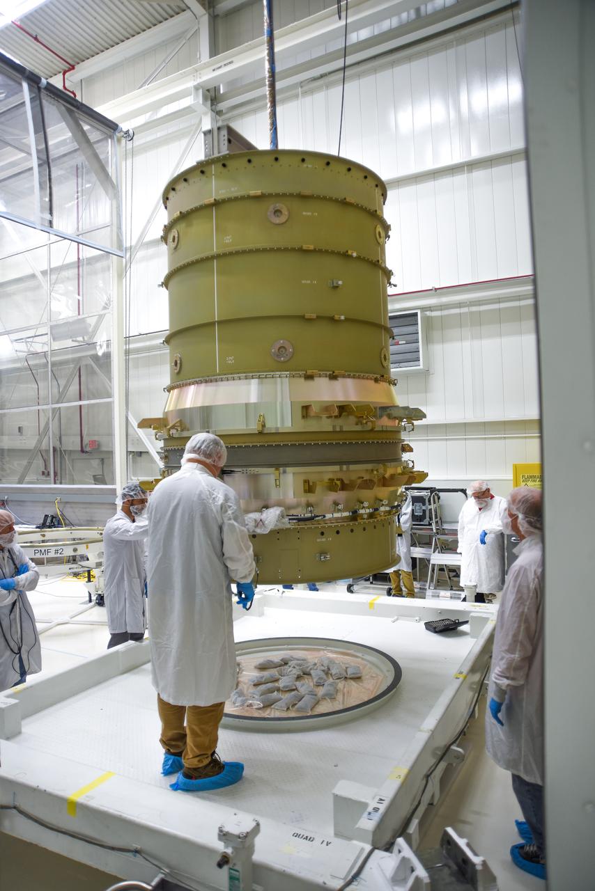 Technicians assist as a crane lowers NASA’s Low-Earth Orbit Flight Test of an Inflatable Decelerator (LOFTID) stack onto a ground transport vehicle  as part of launch preparations occurring inside Building 836 at Vandenberg Space Force Base (VSFB) in California on Sept. 9, 2022. LOFTID is the secondary payload on NASA and the National Oceanic and Atmospheric Administration’s (NOAA) Joint Polar Satellite System-2 (JPSS-2) satellite mission. JPSS-2 is the third satellite in the Joint Polar Satellite System series. It is scheduled to lift off from VSFB on Nov. 1 from Space Launch Complex-3. JPSS-2, which will be renamed NOAA-21 after reaching orbit, will join a constellation of JPSS satellites that orbit from the North to the South pole, circling Earth 14 times a day and providing a full view of the entire globe twice daily. LOFTID will demonstrate inflatable heat shield technology that could enable a variety of proposed NASA missions to destinations such as Mars, Venus, and Titan, as well as returning heavier payloads from low-Earth orbit. 