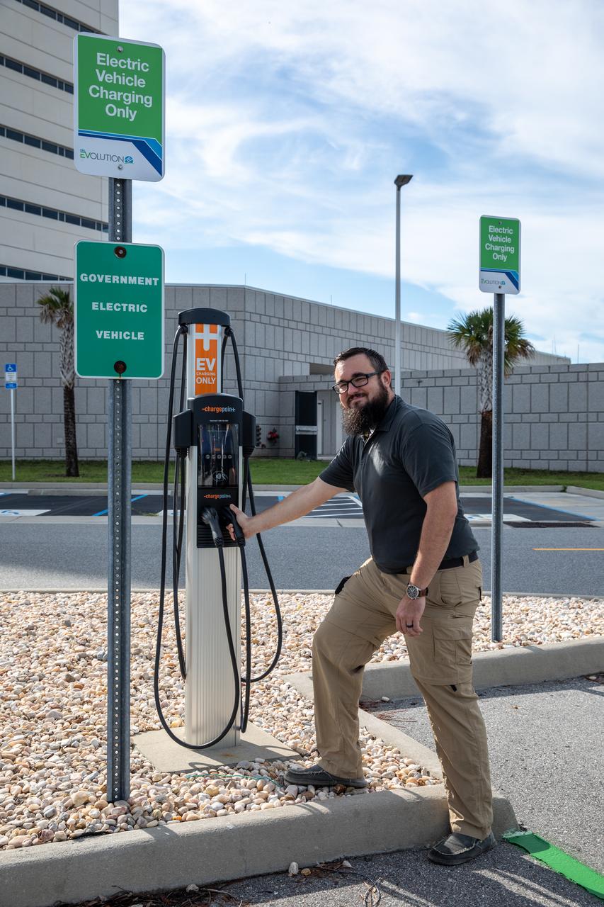 Spencer Davis, a NASA Traffic Management specialist in the Spaceport Integration Directorate at NASA’s Kennedy Space Center in Florida, stands near a newly installed electric vehicle (EV) charging station near the Central Campus Headquarters Building at Kennedy on Sept. 14, 2022. Part of a partnership between Kennedy and Florida Power & Light (FPL) to bring 23 EV charging stations to the spaceport, the ChargePoint CT4000, Level 2 chargers are capable of charging electric vehicles at a rate of 15-30 miles of range per hour. This partnership was set up under FPL’s EV program and provides a charging infrastructure that includes a simple way for businesses and employees to pay for usage.