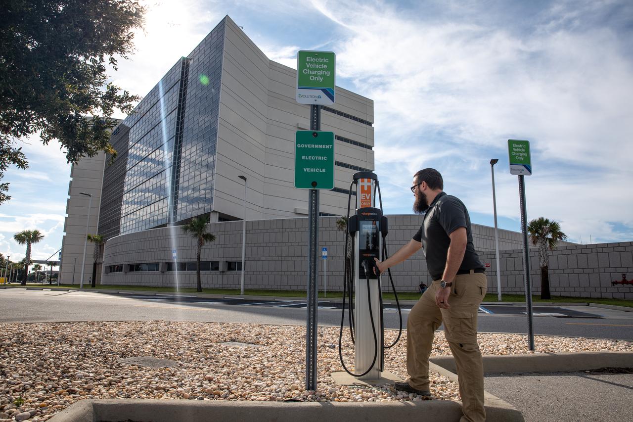 Spencer Davis, a NASA Traffic Management specialist in the Spaceport Integration Directorate at NASA’s Kennedy Space Center in Florida, stands near a newly installed electric vehicle (EV) charging station near the Central Campus Headquarters Building at Kennedy on Sept. 14, 2022. Part of a partnership between Kennedy and Florida Power & Light (FPL) to bring 23 EV charging stations to the spaceport, the ChargePoint CT4000, Level 2 chargers are capable of charging electric vehicles at a rate of 15-30 miles of range per hour. This partnership was set up under FPL’s EV program and provides a charging infrastructure that includes a simple way for businesses and employees to pay for usage.