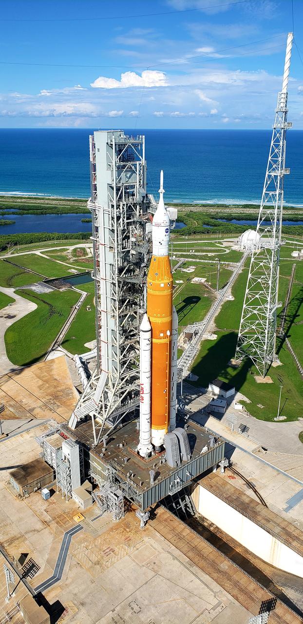 A view of the Artemis I Space Launch System (SLS) and Orion spacecraft atop the mobile launcher on Launch Pad 39B at NASA’s Kennedy Space Center in Florida on Sept. 15, 2022. To the right is one of three lightning protection towers that surround the pad and protect the SLS and Orion from lightning strikes. Artemis I is the first integrated test of the SLS and Orion spacecraft. In future Artemis missions, NASA will land the first woman and the first person of color on the surface of the Moon, paving the way for a long-term lunar presence and serving as a steppingstone on the way to Mars.