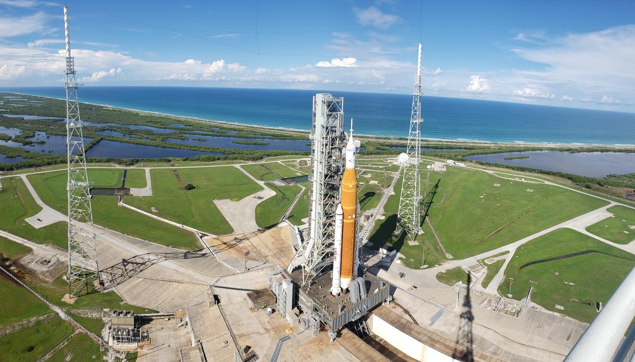 A view of the Artemis I Space Launch System (SLS) and Orion spacecraft atop the mobile launcher on Launch Pad 39B at NASA’s Kennedy Space Center in Florida on Sept. 15, 2022. Also in view are two of the three lightning towers that surround the pad and protect the SLS and Orion from lightning strikes. Artemis I is the first integrated test of the SLS and Orion spacecraft. In future Artemis missions, NASA will land the first woman and the first person of color on the surface of the Moon, paving the way for a long-term lunar presence and serving as a steppingstone on the way to Mars. 