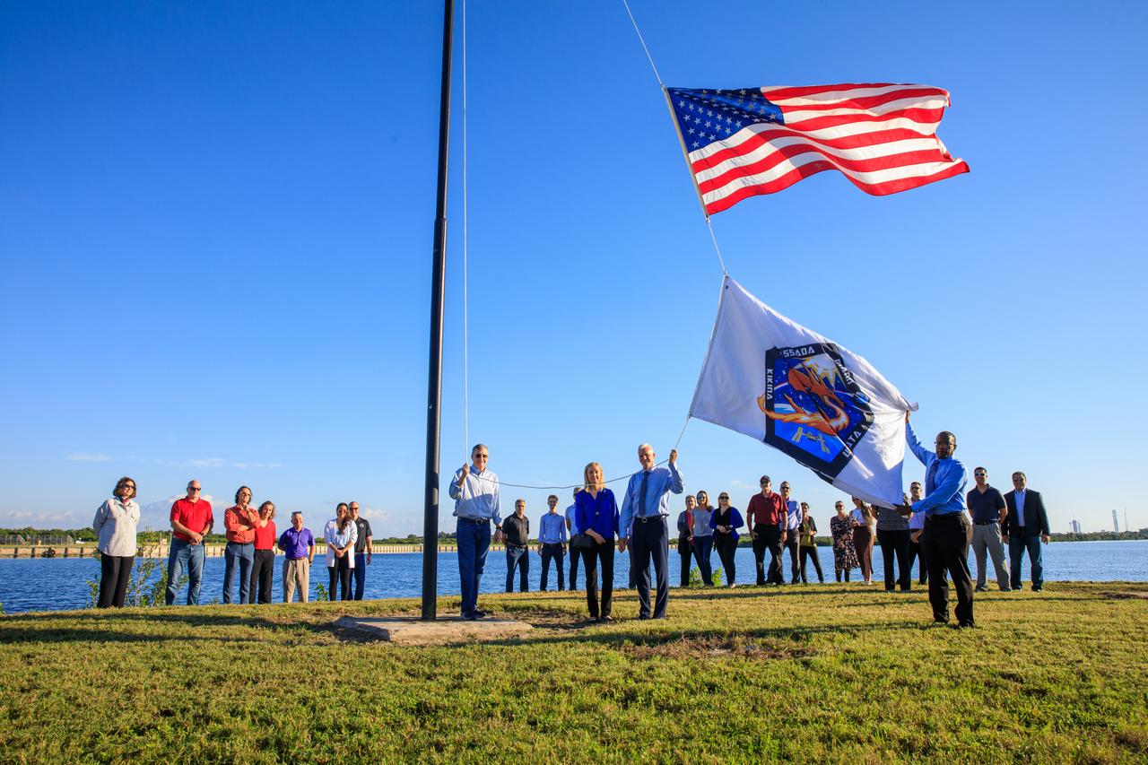 NASA Commercial Crew Program (CCP) employees Tyrell Hawkins (right) and Henry May (second from right) raise the Crew-5 flag near the countdown clock at the Press Site at NASA’s Kennedy Space Center in Florida on Oct. 3, 2022. Next to May is his wife, and to the left is CCP Manager Steve Stich. NASA’s SpaceX Crew-5 mission will carry NASA astronauts Josh Cassada and Nicole Aunapu Mann, Roscosmos cosmonaut Anna Kikina, and JAXA (Japan Aerospace Exploration Agency) to the International Space Station for a science expedition mission as part of the agency’s CCP. SpaceX’s Falcon 9 rocket and Crew Dragon Endurance spacecraft are scheduled to lift off from Kennedy’s Launch Complex 39A at noon EDT on Oct. 5, 2022.
