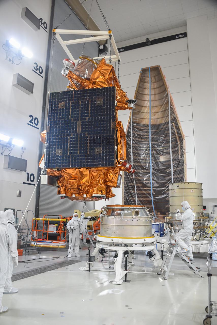 Technicians assist as a crane is used to move the National Oceanic and Atmospheric Administration’s Joint Polar Satellite System (JPSS-2) for mating to the spacecraft adapter inside the Astrotech Space Operations facility at Vandenberg Space Force Base (VSFB) in California on Oct. 4, 2022. JPSS-2 is the third satellite in the Joint Polar Satellite System series. It is scheduled to lift off from VSFB on Nov. 1 from Space Launch Complex-3. JPSS-2, which will be renamed NOAA-21 after reaching orbit, will join a constellation of JPSS satellites that orbit from the North to the South pole, circling Earth 14 times a day and providing a full view of the entire globe twice daily. 