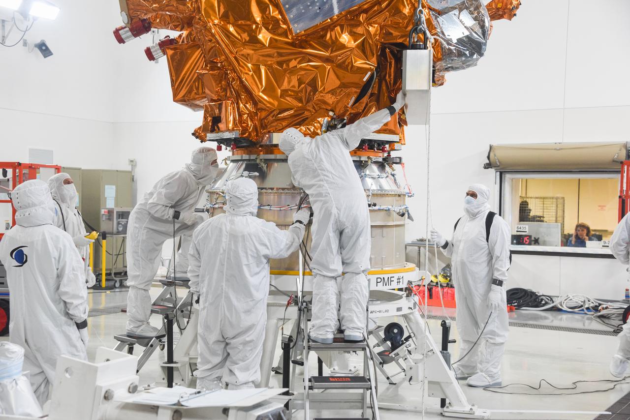 Technicians assist as a crane is used to lower the National Oceanic and Atmospheric Administration’s Joint Polar Satellite System (JPSS-2) onto the spacecraft adapter inside the Astrotech Space Operations facility at Vandenberg Space Force Base (VSFB) in California on Oct. 4, 2022. JPSS-2 is the third satellite in the Joint Polar Satellite System series. It is scheduled to lift off from VSFB on Nov. 1 from Space Launch Complex-3. JPSS-2, which will be renamed NOAA-21 after reaching orbit, will join a constellation of JPSS satellites that orbit from the North to the South pole, circling Earth 14 times a day and providing a full view of the entire globe twice daily. 
