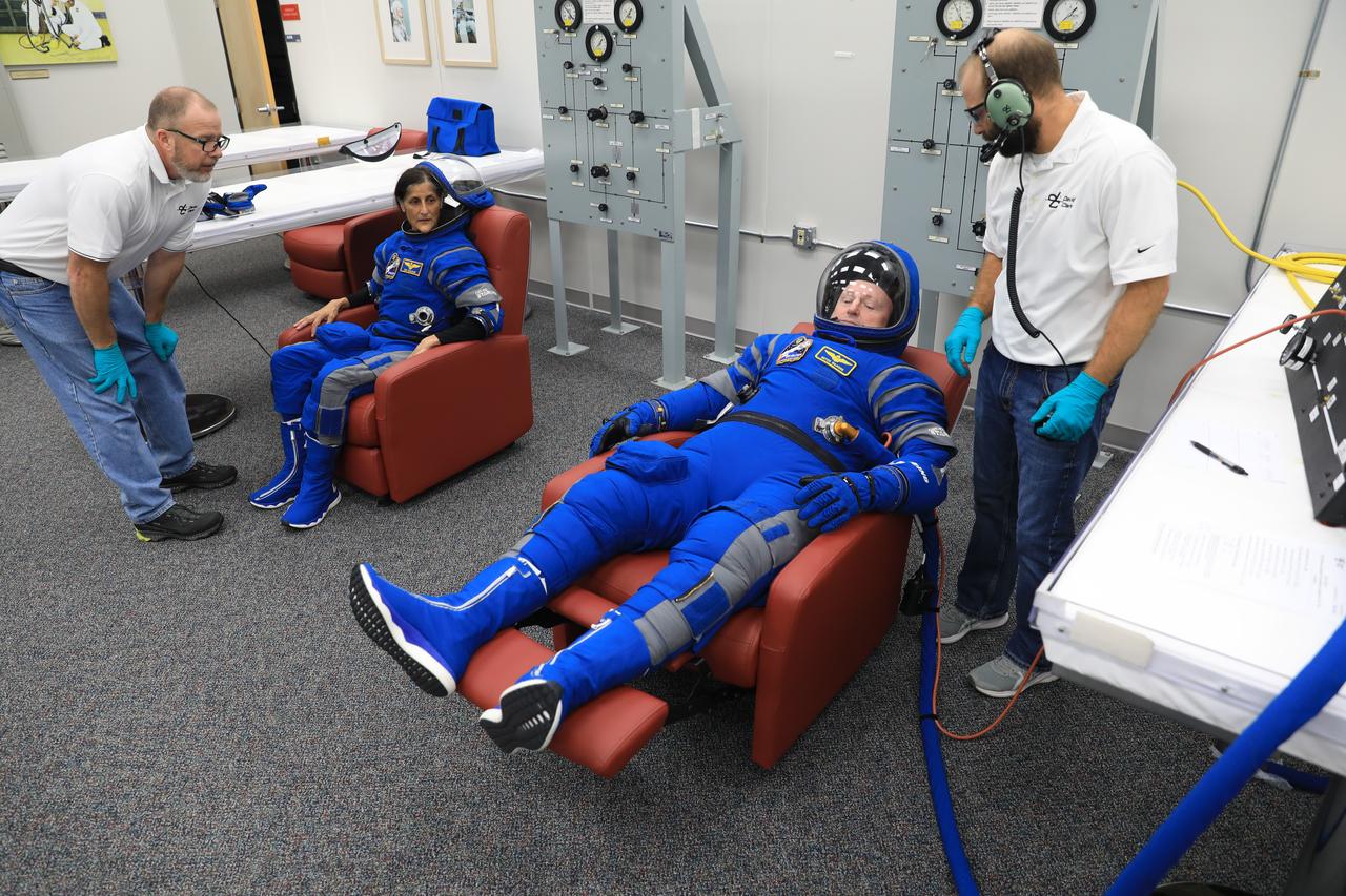 From left, NASA astronaut Suni Williams, Boeing Crew Flight Test (CFT) pilot, watches as NASA astronaut Barry “Butch” Wilmore, CFT commander, checks out his spacesuit and helmet during a crew validation test inside the Astronaut Crew Quarters at NASA’s Kennedy Space Center in Florida on Oct. 18, 2022. Williams and Wilmore, along with Mike Fincke, CFT backup spacecraft test pilot, with assistance from the Boeing team, successfully completed the validation test during which they suited up and tested out the pressurized crew module to ensure seat fit, suit functionality, cabin temperature, audio system, and day of launch operations. Boeing’s CFT is scheduled to launch in April 2023.