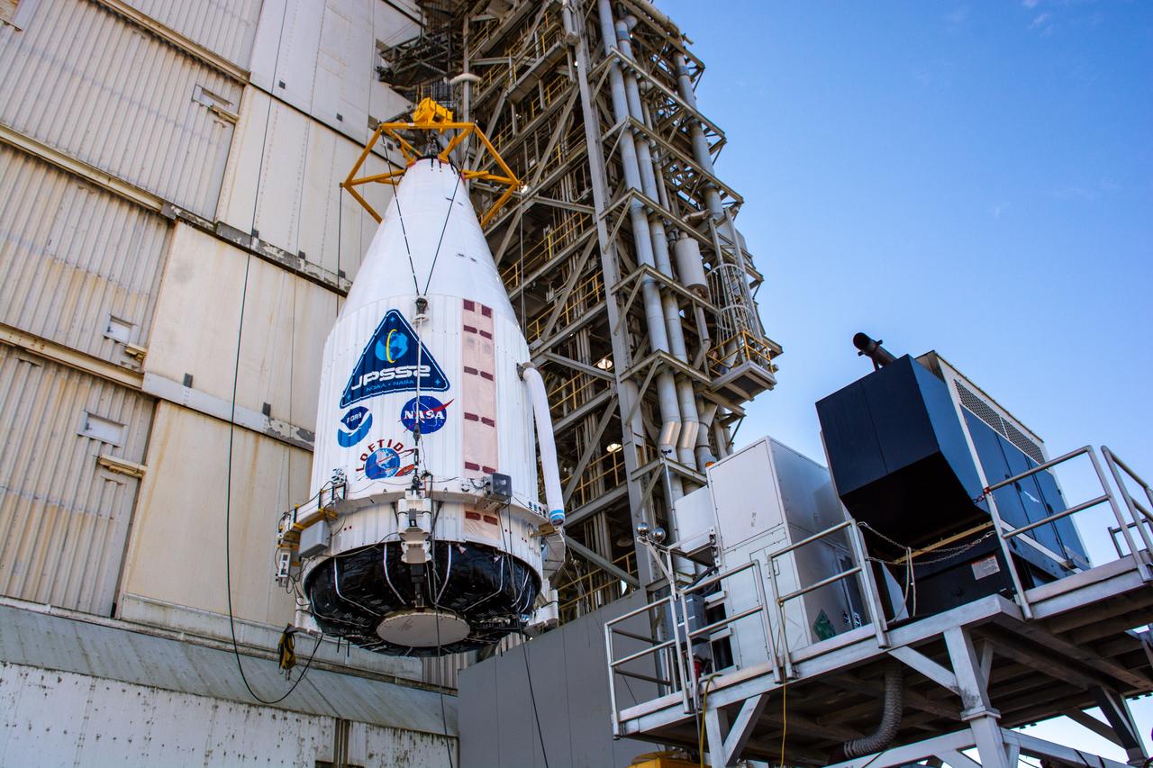 A close-up view of the United Launch Alliance Atlas V payload fairing containing the National Oceanic and Atmospheric Administration’s (NOAA) Joint Polar Satellite System-2 (JPSS-2) as it is hoisted up by crane at the vertical integration facility at Space Launch Complex 3 at Vandenberg Space Force Base (VSFB) in California on Oct. 18, 2022. Inside the fairing, JPSS-2 is stacked atop NASA’s Low-Earth Orbit Flight Test of an Inflatable Decelerator (LOFTID) secondary payload. JPSS-2 is the third satellite in the Joint Polar Satellite System series. It is scheduled to lift off from VSFB on Nov. 1 from SLC-3. JPSS-2, which will be renamed NOAA-21 after reaching orbit, will join a constellation of JPSS satellites that orbit from the North to the South pole, circling Earth 14 times a day and providing a full view of the entire globe twice daily. The NOAA/NASA Suomi National Polar-orbiting Partnership (Suomi NPP) satellite, and NOAA-20, previously known as JPSS-1, are both already in orbit. Each satellite carries at least four advanced instruments to measure weather and climate conditions on Earth. LOFTID is dedicated to the memory of Bernard Kutter. LOFTID will demonstrate inflatable heat shield technology that could enable a variety of proposed NASA missions to destinations such as Mars, Venus, and Titan, as well as returning heavier payloads from low-Earth orbit.