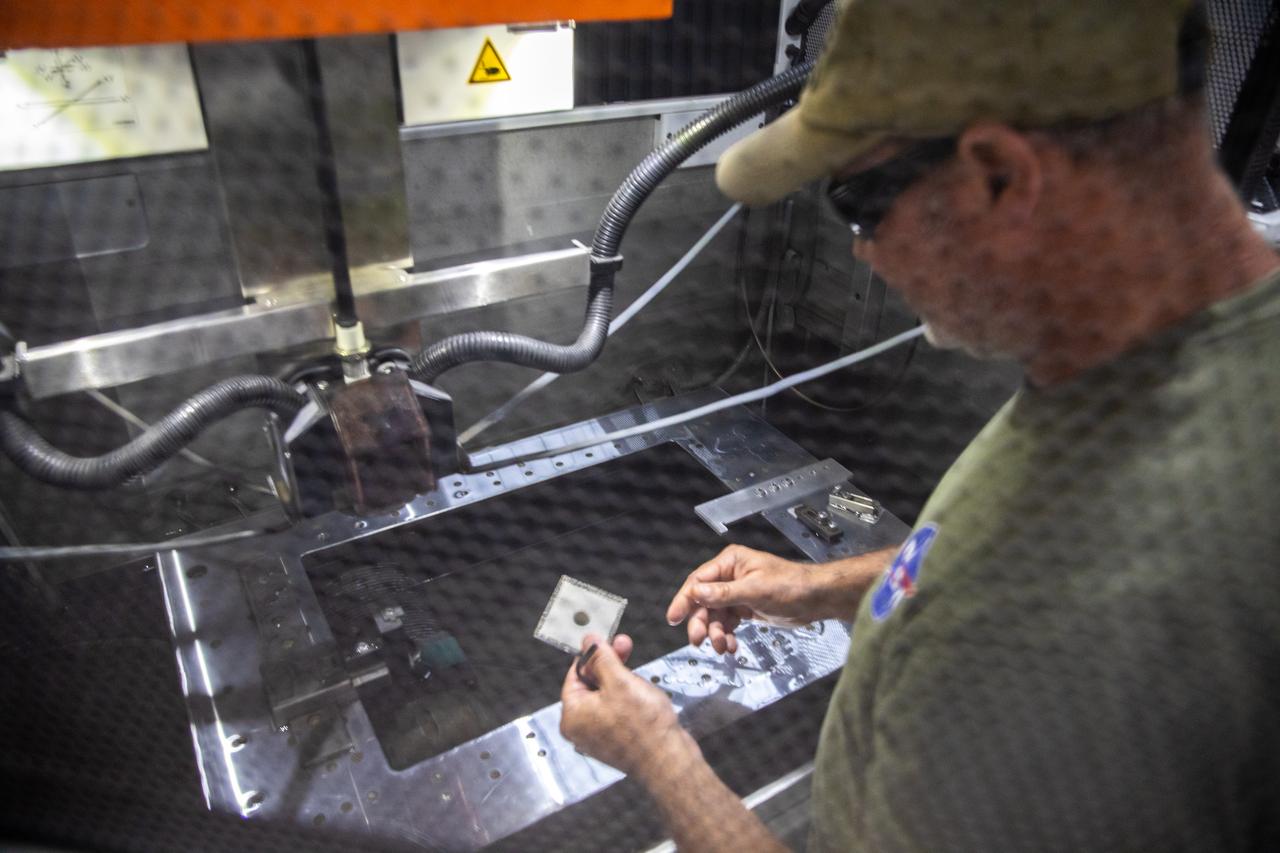 Gerard Moscoso, a mechanical engineer technician with NASA, prepares a sample for testing for the  Plasma Rapid Oxidation Technique for Extending Component Tenability (PROTECT) project inside the Prototype Development Laboratory at NASA’s Kennedy Space Center in Florida on Nov. 2, 2022. Plasma electrolytic oxidation is a surface coating technology that produces oxide layers on the surface of light metals and their alloys to improve their performance characteristics. These coatings are tailored to provide a combination of characteristics such as corrosion protection, wear resistance, thermal management, extreme hardness, and fatigue performance. PROTECT is expected to demonstrate a 10 percent improved fatigue performance and a 70 percent improvement in corrosion characteristics on the interior of treated 3-D printed metallic parts when compared to non-treated parts. PROTECT could be applied on spacecraft and launch vehicles. 