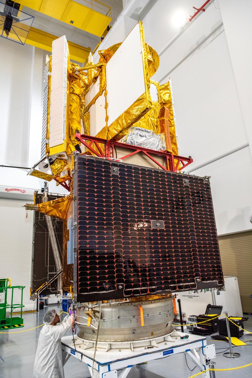 Inside the SpaceX facility at Vandenberg Space Force Base in California, a technician helps secure the Surface Water and Ocean Topography (SWOT) satellite onto the payload adapter on Dec. 5, 2022. A collaboration between NASA and the French space agency Centre National d’Études Spatiales (CNES), with contributions from the Canadian Space Agency and the UK Space Agency, SWOT will be the first satellite to survey nearly all water on Earth’s surface. SWOT is scheduled to lift off aboard the SpaceX Falcon 9 rocket from Vandenberg on Dec. 15, 2022, at 3:46 a.m. PST. 