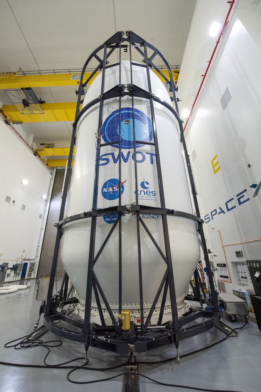 Inside the SpaceX facility at Vandenberg Space Force Base in California, decal fixtures are placed on the SpaceX Falcon 9 payload fairing of the Surface Water and Ocean Topography (SWOT) satellite on Dec. 9, 2022. A collaboration between NASA and the French space agency Centre National d’Études Spatiales (CNES), with contributions from the Canadian Space Agency and the UK Space Agency, SWOT will be the first satellite to survey nearly all water on Earth’s surface. SWOT is scheduled to lift off aboard the SpaceX Falcon 9 rocket from Vandenberg on Dec. 15, 2022, at 3:46 a.m. PST.