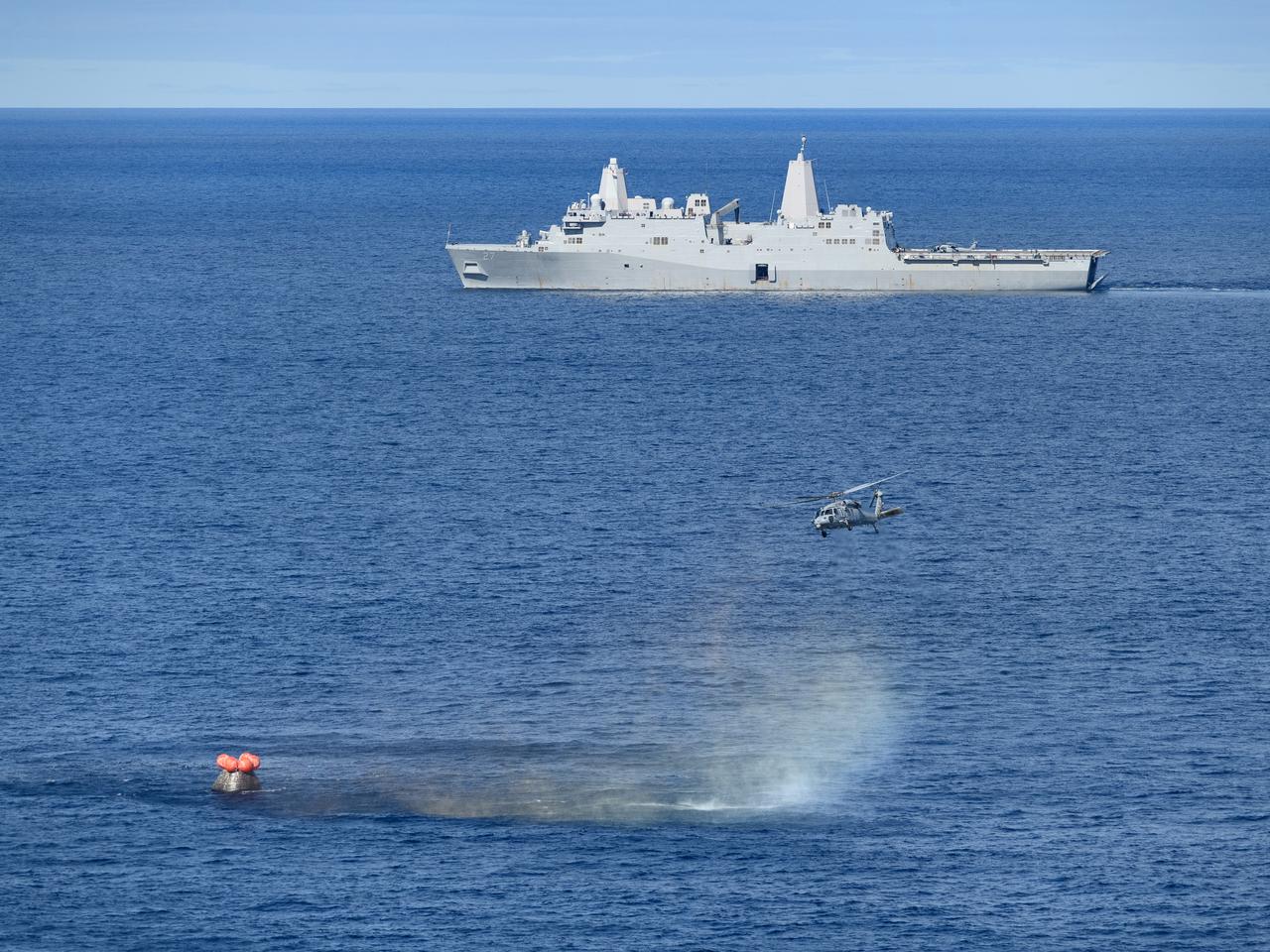 At 12:40 p.m. EST, Dec. 11, 2022, NASA’s Orion spacecraft for the Artemis I mission splashed down in the Pacific Ocean with the USS Portland seen in the distance after a 25.5 day mission to the Moon. Orion will be recovered by NASA’s Landing and Recovery team, U.S. Navy and Department of Defense partners aboard the USS Portland.