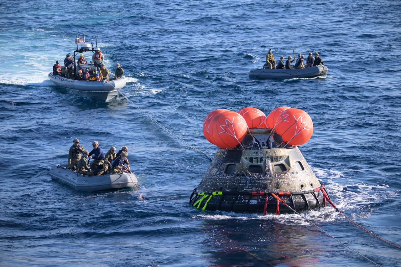 After splashing down at 12:40 p.m. EST on Dec. 11, 2022, U.S. Navy divers help recover the Orion Spacecraft for the Artemis I mission. NASA, the Navy and other Department of Defense partners worked together to secure the spacecraft inside the well deck of USS Portland approximately five hours after Orion splashed down in the Pacific Ocean off the coast of California.