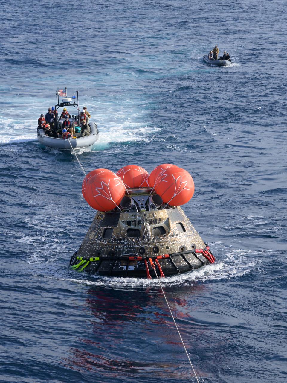 After splashing down at 12:40 p.m. EST on Dec. 11, 2022, U.S. Navy divers help recover the Orion Spacecraft for the Artemis I mission. NASA, the Navy and other Department of Defense partners worked together to secure the spacecraft inside the well deck of USS Portland approximately five hours after Orion splashed down in the Pacific Ocean off the coast of California.