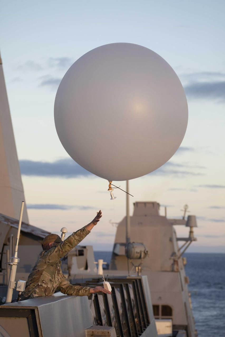 A member of the 45th Weather Squadron out of Patrick Space Force Base releases a weather balloon from the deck of USS Portland prior to splashdown of the NASA’s Orion spacecraft for the Artemis I mission on Dec. 11, 2022.