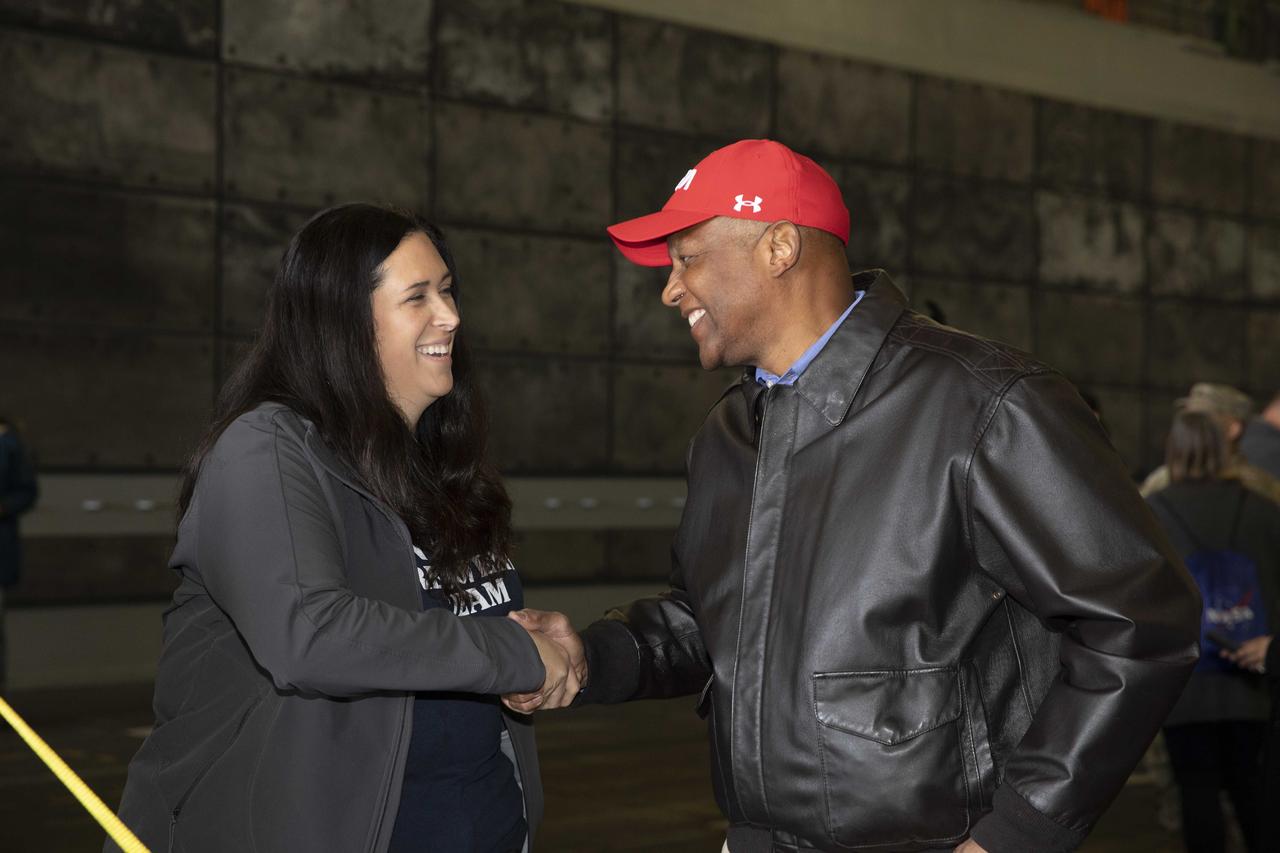 NASA Artemis I Recovery Director Melissa Jones, at right, with Exploration Ground Systems, shakes hands with Kennedy Space Center Deputy Director Kelvin Manning inside the well deck of the USS Portland at U.S. Naval Base San Diego on Dec. 13, 2022. The Artemis I Orion spacecraft is secured inside the well deck after splashing down at 12:40 p.m. EST on Dec. 11, 2022. U.S. Navy divers helped recover the Orion spacecraft. NASA, the Navy and other Department of Defense partners worked together to secure the spacecraft inside the ship’s well deck approximately five hours after Orion splashed down in the Pacific Ocean off the coast of Baja, California.