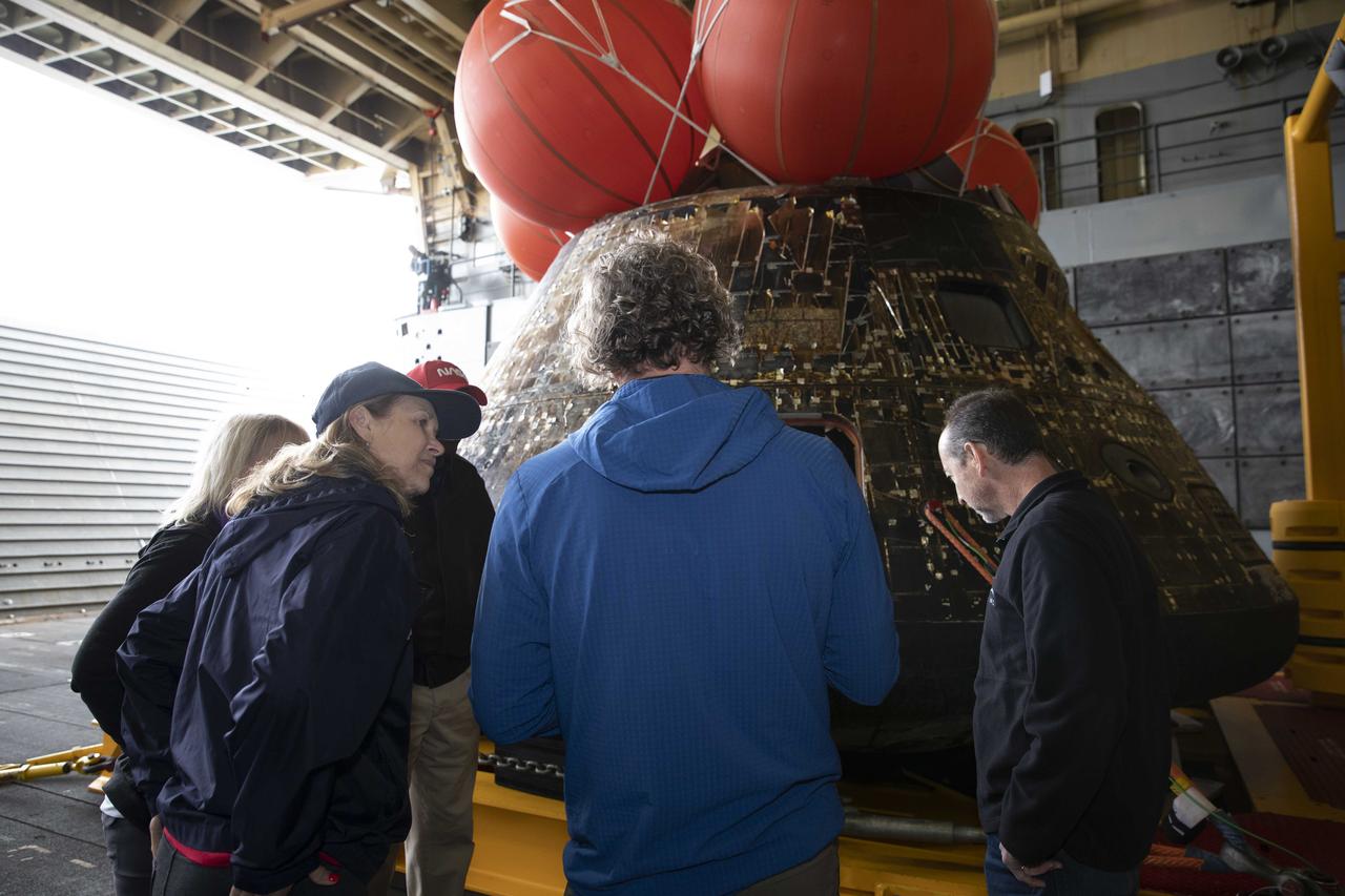 Kennedy Space Center Director Janet Petro, third from left, and recovery team members look at the Artemis I Orion spacecraft inside the well deck of the USS Portland at U.S. Naval Base San Diego on Dec. 13, 2022. The Orion spacecraft is secured inside the well deck after splashing down at 12:40 p.m. EST on Dec. 11, 2022. U.S. Navy divers helped recover the Orion spacecraft. NASA, the Navy and other Department of Defense partners worked together to secure the spacecraft inside the ship’s well deck approximately five hours after Orion splashed down in the Pacific Ocean off the coast of Baja, California. 