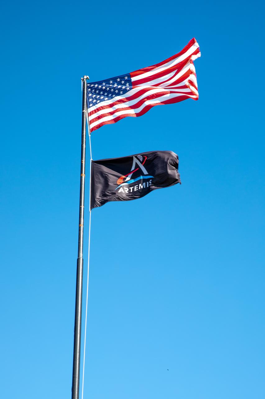The Artemis flag is removed from NASA News Center property at the agency’s Kennedy Space Center in Florida on Jan. 6, 2023, following the successful Artemis I mission. At left is former Exploration Ground Systems (EGS) Senior Technical Integration Manager Phil Weber, joined by former EGS Manager Mike Bolger. Both men served in their respective roles during Artemis I, retiring at the end of 2022. NASA’s Space Launch System (SLS) rocket and Orion spacecraft lifted off from Kennedy’s Launch Complex 39B on Nov. 16, 2022. Orion splashed down in the Pacific Ocean on Dec. 11 and arrived back at Kennedy on Dec. 30. Artemis I sets the stage for the next mission of SLS and Orion to fly crew around the Moon on Artemis II.