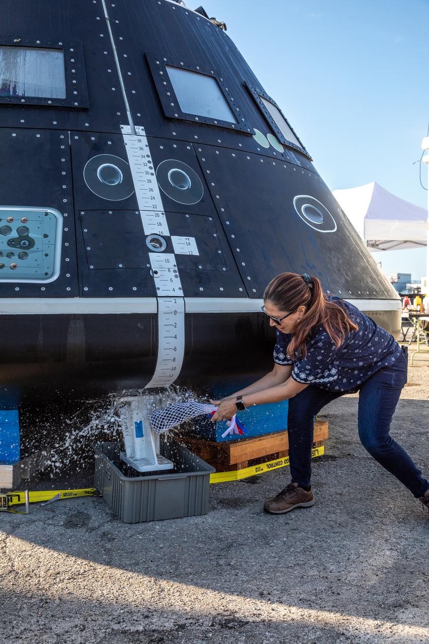 Liliana Villarreal, Artemis landing and recovery director with Exploration Ground Systems (EGS), christens the Crew Module Test Article (CMTA) with champagne during a naming ceremony at the turn basin in the Launch Complex 39 area at NASA’s Kennedy Space Center in Florida on Jan. 30, 2023. The CMTA is being used to practice recovery after splashdown of the Orion spacecraft to prepare for the Artemis II crewed mission. EGS leads recovery efforts.