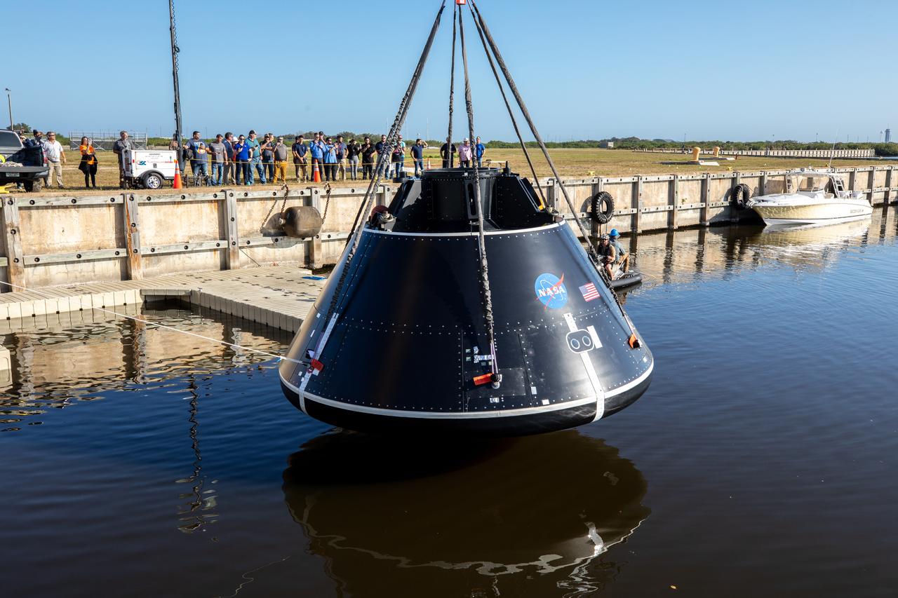 A crane lowers the Crew Module Test Article (CMTA) into water at the turn basin in the Launch Complex 39 area at NASA’s Kennedy Space Center in Florida on Jan. 30, 2023. The CMTA is being used to practice recovery after splashdown of the Orion spacecraft to prepare for the Artemis II crewed mission. Exploration Ground Systems leads recovery efforts. 