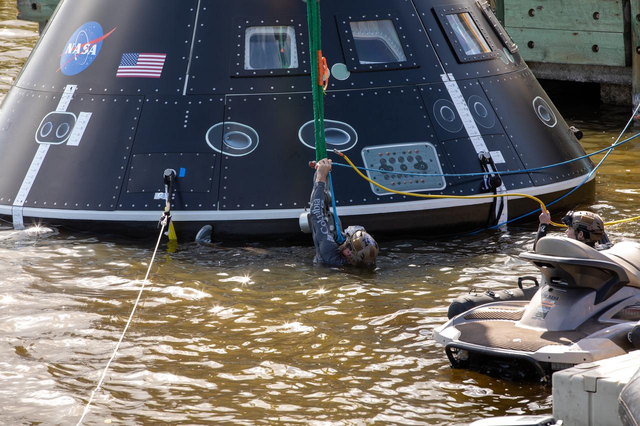 Landing and recovery team members secure the Crew Module Test Article (CMTA) in the water at the turn basin in the Launch Complex 39 area at NASA’s Kennedy Space Center in Florida on Jan. 30, 2023. The CMTA is being used to practice recovery after splashdown of the Orion spacecraft to prepare for the Artemis II crewed mission. Exploration Ground Systems leads recovery efforts.