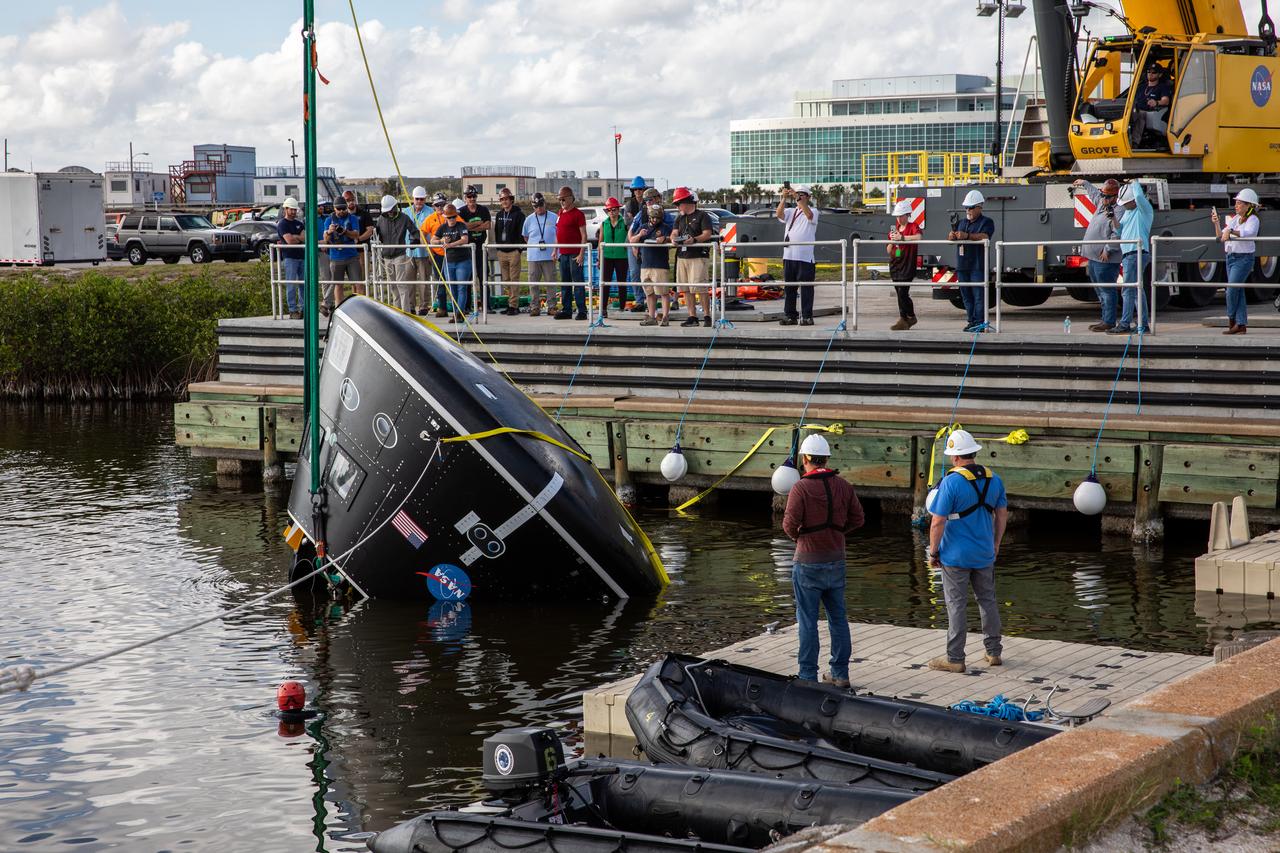 A crane is used to rotate the Crew Module Test Article (CMTA) in the water at the turn basin in the Launch Complex 39 area at NASA’s Kennedy Space Center in Florida on Jan. 31, 2023. The CMTA is being certified for use to practice recovery after splashdown of the Orion spacecraft to prepare for the Artemis II crewed mission. Exploration Ground Systems leads recovery efforts. 