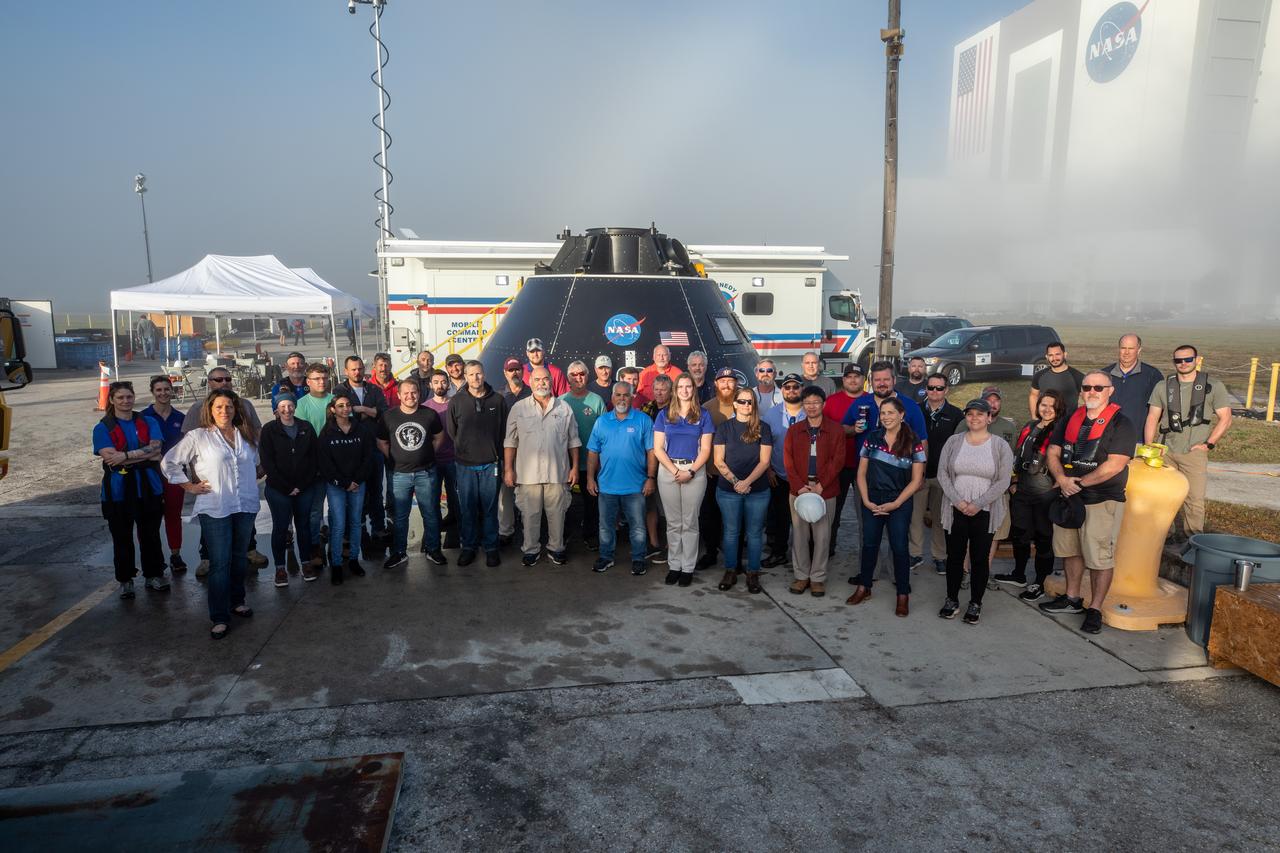 Members of the Exploration Ground Systems (EGS) landing and recovery team gather for a group photograph in front of the Crew Module Test Article (CMTA) at the turn basin in the Launch Complex 39 area at NASA’s Kennedy Space Center in Florida on Feb. 1, 2023. The CMTA is being used to practice recovery after splashdown of the Orion spacecraft to prepare for the Artemis II crewed mission. EGS leads recovery efforts. 