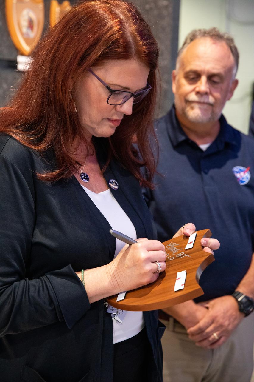Artemis Launch Director Charlie Blackwell-Thompson, at left, signs the back of the Artemis I plaque inside the lobby of the Launch Control Center at NASA’s Kennedy Space Center in Florida on March 24, 2023. Joining her is Shawn Quinn, manager, Exploration Ground Systems. Following tradition from the Apollo and Space Shuttle Programs, the plaque will be added to the wall behind them. The first in a series of increasingly complex missions, Artemis I launched successfully from Kennedy’s Launch Pad 39B at 1:47 a.m. EST on Nov. 16, 2022. 