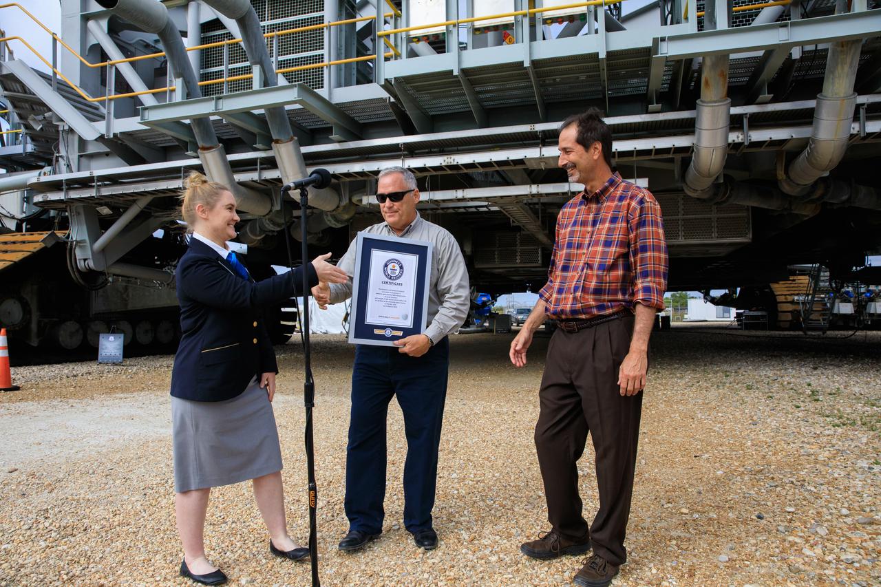 Guinness World Records adjudicator Hannah Ortman shakes hands with Brett Raulerson, Jacobs TOSC Crawlers, Transporters and Structures group manager, left, and John Giles, NASA’s Crawler Element Operations manager, during a ceremony on March 29, 2023, at the agency’s Kennedy Space Center in Florida. Guinness World Records officially designated NASA’s Crawler Transporter 2 as the heaviest self-powered vehicle, weighing approximately 6.65 million pounds. The crawler is responsible for carrying the Space Launch System rocket and Orion spacecraft for the Artemis missions to and from the launch pad.