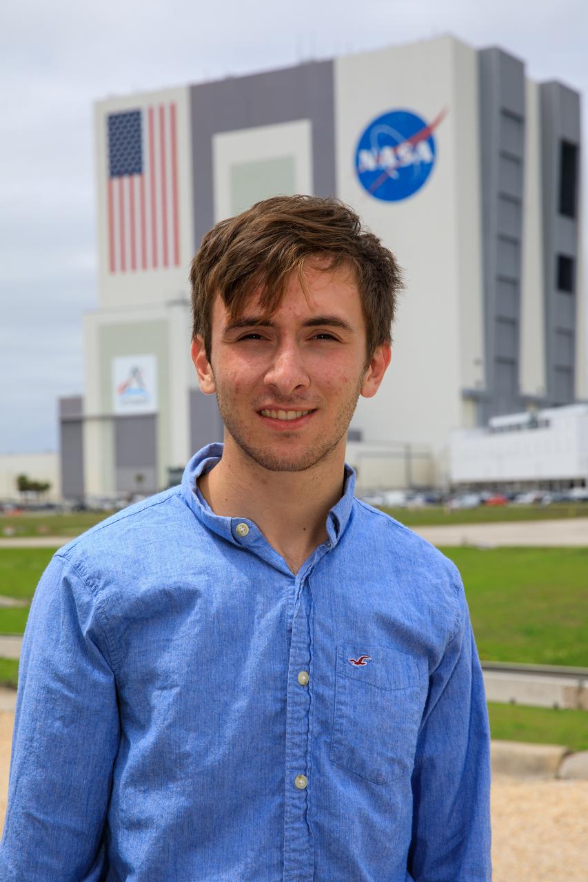 Jonah Saunders, Electrical Engineering Pathways Intern, poses in front of Vehicle Assembly Building at NASA’s Kennedy Space Center in Florida on April 17, 2023. 