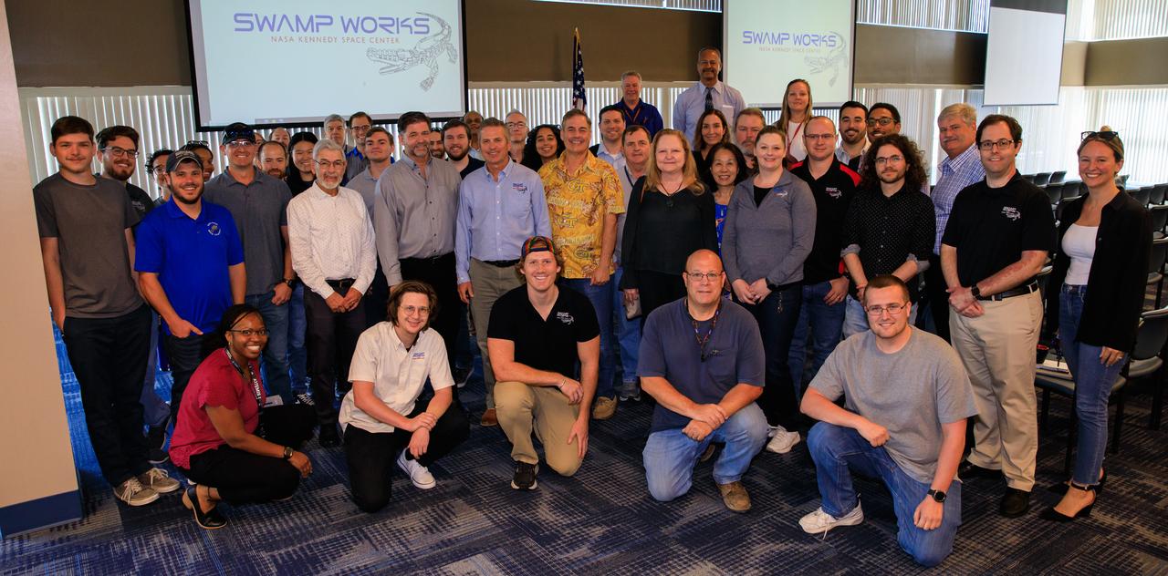 To celebrate its 10-year anniversary, the Swamp Works team poses for a group photograph inside the Space Station Processing Facility conference room at NASA’s Kennedy Space Center in Florida on April 21, 2023. Swamp Works includes several laboratories where hands-on, cutting-edge technology is developed for NASA and its exploration goals, as well as for benefits on Earth. 