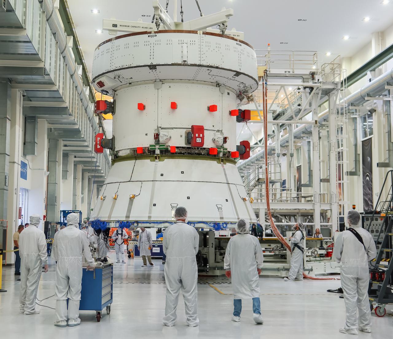 Engineers and technicians monitor the progress as the European Service Module (ESM) for NASA’s Artemis II mission is lifted by crane inside the high bay of the Neil A. Armstrong Operations and Checkout Building at NASA’s Kennedy Space Center in Florida on May 22, 2023. Teams from NASA and Lockheed Martin are preparing the service module for transfer to the FAST (final assembly and system testing) cell for final checkouts before it is stacked with the Orion crew module.. The powerhouse that will fuel and propel Orion in space, the ESM will be used for Artemis II, the first Artemis mission flying crew aboard Orion. 