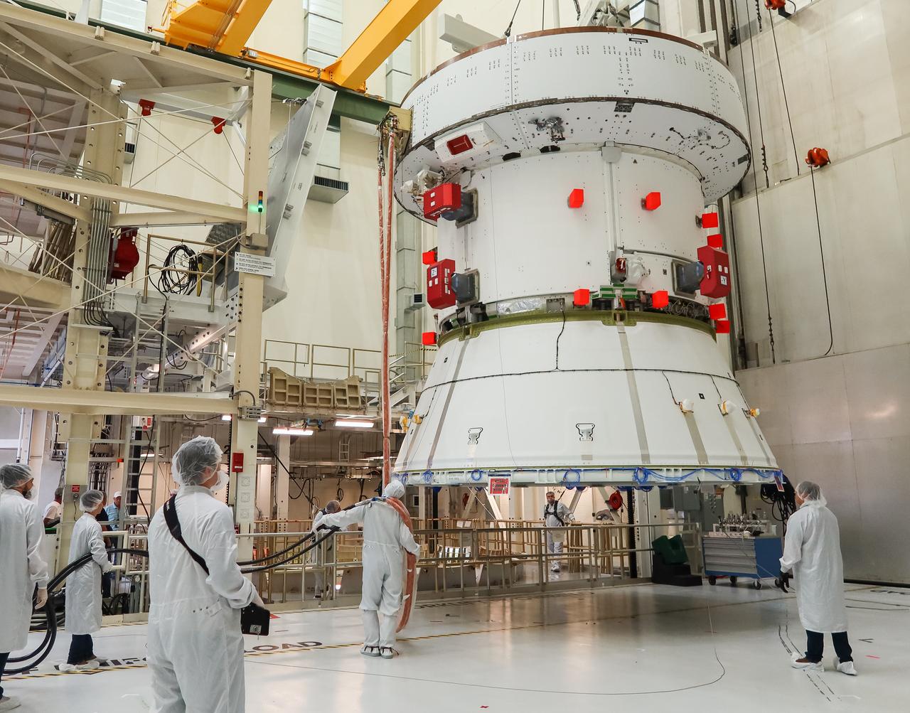 A crane moves the European Service Module (ESM) for NASA’s Artemis II mission along the center aisle of the high bay inside the Neil A. Armstrong Operations and Checkout Building at NASA’s Kennedy Space Center in Florida on May 22, 2023. Teams from NASA and Lockheed Martin are transferring the service module to the FAST (final assembly and system testing) cell for final checkouts before it is stacked with the Orion crew module.. The powerhouse that will fuel and propel Orion in space, the ESM will be used for Artemis II, the first Artemis mission flying crew aboard Orion. 