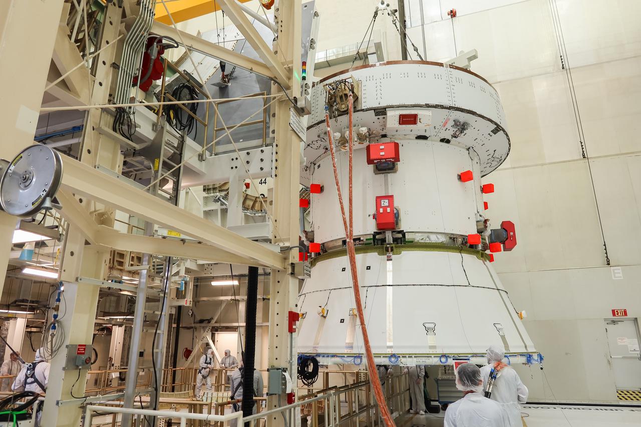 A crane slowly moves the European Service Module (ESM) for NASA’s Artemis II mission into the FAST (final assembly and system testing) cell inside the high bay of the Neil A. Armstrong Operations and Checkout Building at NASA’s Kennedy Space Center in Florida on May 22, 2023. Teams from NASA and Lockheed Martin are transferring the service module to the FAST cell for final checkouts before it is stacked with the Orion crew module.. The powerhouse that will fuel and propel Orion in space, the ESM will be used for Artemis II, the first Artemis mission flying crew aboard Orion. 