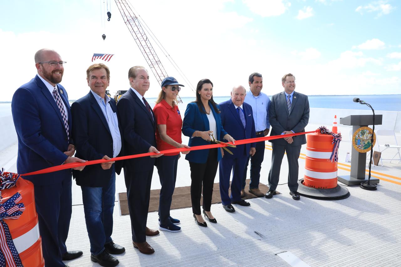 A ribbon cutting ceremony on the upgraded eastbound span of the Indian River Bridge is held on June 9, 2023 near NASA’s Kennedy Space Center in Florida. From left are Florida Department of Transportation State Secretary Jared Perdue; Florida State House Representative Thad Altman; Florida State Senator Tom Wright; Kennedy Space Center Director Janet Petro; Florida Lieutenant Governor Jeanette Nuñez (cutting the ribbon); Frank DiBello, Space Florida President/Chief Executive Officer; Florida State House Representative Tyler Sirois; and FDOT District Five Secretary John Tyler. The new high-rise bridge serves as the primary entrance and exit to the space center for employees and visitors. The bridge spans the Indian River Lagoon and connects Kennedy and the Cape Canaveral Space Force Station to the mainland via State Road 405/NASA Causeway in Titusville. This first section of the bridge replaces the two-lane drawbridge which was built in the mid-1960s to support the Apollo program. 