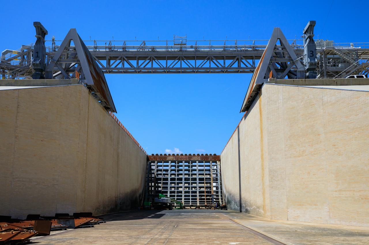 Teams with Exploration Ground Systems at NASA’s Kennedy Space Center in Florida continue to work the upgrades and repairs on mobile launcher 1 and Launch Pad 39B on June 13, 2023, ahead of the first critical ground testing for Artemis II. Teams are re-designing the panels on the flame deflector in the flame trench that withstood damage observed after launch of Artemis I. Artemis II will be the first Artemis mission flying crew aboard Orion. 