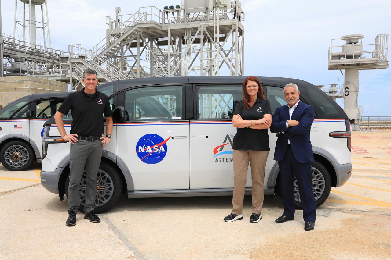 Three specially designed, fully electric, environmentally friendly crew transportation vehicles for Artemis missions arrived at NASA’s Kennedy Space Center in Florida on July 11, 2023. One of the zero-emission vehicles is shown here at Launch Pad 39B. From left are Jeremy Graeber, Artemis assistant launch director; Charlie Blackwell-Thompson, Artemis launch director; and Tony Aquila, chairman and CEO, Canoo Technologies Inc.. The fleet, which will carry astronauts to Launch Complex 39B for Artemis missions, was delivered by the manufacturer, Canoo Technologies Inc. of Torrance, California.