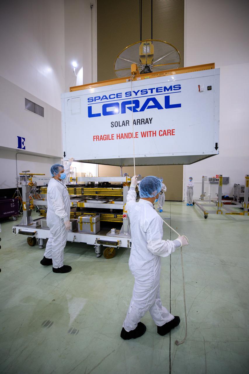 A NASA team lifts the cover off the twin solar arrays for NASA’s Psyche spacecraft at the Astrotech Space Operations Facility near the agency’s Kennedy Space Center in Florida on July 18, 2023. The solar arrays were shipped from Maxar Technologies, in San Jose, in California. They are part of the solar electric propulsion system, provided by Maxar, that will power the spacecraft on its journey to explore a metal-rich asteroid. Psyche will launch atop a SpaceX Falcon Heavy rocket from Launch Complex 39A at Kennedy. Launch is targeted for Oct. 5, 2023. Riding with Psyche is a pioneering technology demonstration, NASA’s Deep Space Optical Communications (DSOC) experiment.