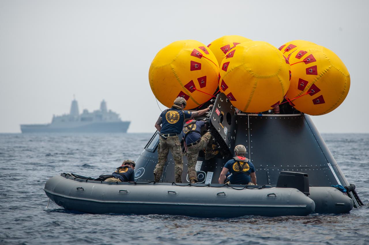 NASA, Navy, and Air Force personnel practice Artemis recovery procedures in the Pacific Ocean as part of Underway Recovery Test-10 off the coast of San Diego. In this photo Navy divers are seen entering the Orion Crew Module Test Article to prepare to practice recovering astronauts out of the spacecraft and onto an inflatable “front porch” where the crew will be picked up with helicopters and lifted up via helicopter back to the recovery vessel.