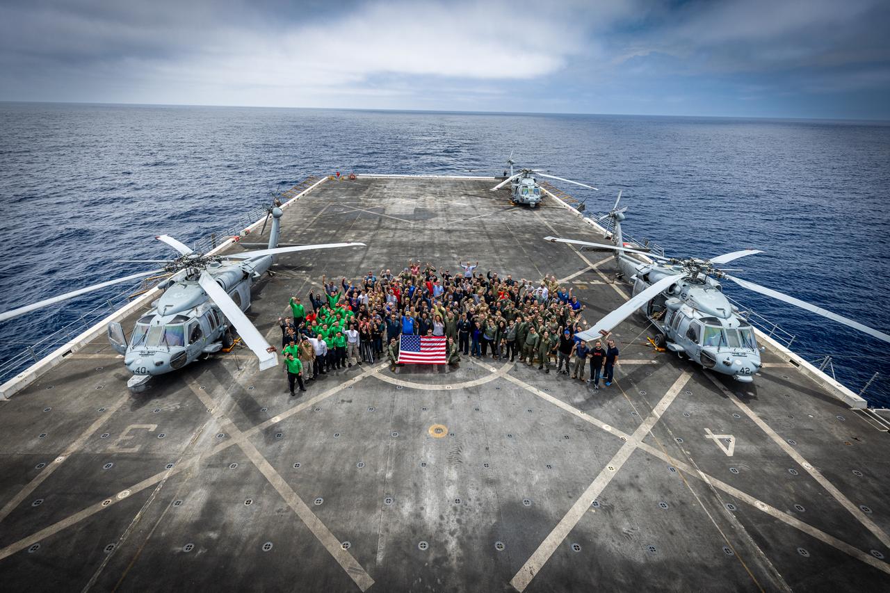 Members of NASA’s Landing and Recovery team and partners from the Department of Defense stand on the flight deck of USS John P. Murtha during Underway Recovery Test 10 (URT-10) off the coast of San Diego. URT-10 is the tenth in a series of Artemis recovery tests, but the first time NASA and its partners from the Department of Defense put their Artemis II recovery procedures to the test.