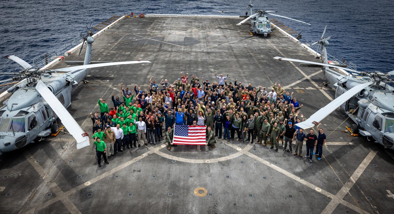 Members of NASA’s Landing and Recovery team and partners from the Department of Defense stand on the flight deck of USS John P. Murtha during Underway Recovery Test 10 (URT-10) off the coast of San Diego. URT-10 is the tenth in a series of Artemis recovery tests, but the first time NASA and its partners from the Department of Defense put their Artemis II recovery procedures to the test.