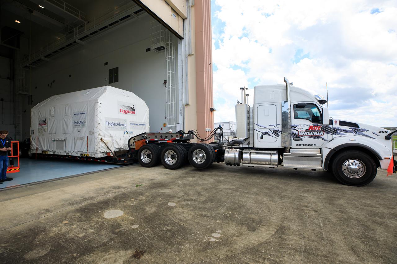 The Northrop Grumman Cygnus spacecraft's pressurized cargo module (PCM) arrives at the Space Station Processing Facility of NASA's Kennedy Space Center in Florida on Aug. 2, 2023. The PCM is sealed in an environmentally controlled shipping container, pulled in by truck on a flatbed trailer. Cygnus will launch later this year atop a SpaceX Falcon 9 rocket from Cape Canaveral Space Force Station’s Space Launch Complex 40 to the International Space Station. Cygnus will undergo prelaunch processing at Kennedy before it is transported to SpaceX’s integration facility.