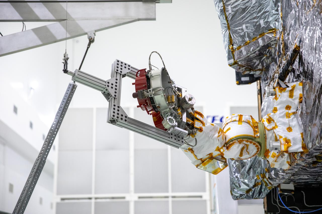 A team of engineers and technicians work on deploying and stowing stationary plasma thrusters (SPT) on NASA's Psyche spacecraft inside the Astrotech Space Operations Facility near the agency’s Kennedy Space Center in Florida on Aug. 4, 2023. This is part of the assembly, test, and launch operations preparations. The SPT are on a dual axis positioning mechanism (DAPM), and together they make a DSM, or DAPM-actuated SPT module. Psyche will launch atop a SpaceX Falcon Heavy rocket from Launch Complex 39A at Kennedy. Launch is targeted for Oct. 5, 2023. Riding with Psyche is a pioneering technology demonstration, NASA’s Deep Space Optical Communications (DSOC) experiment.